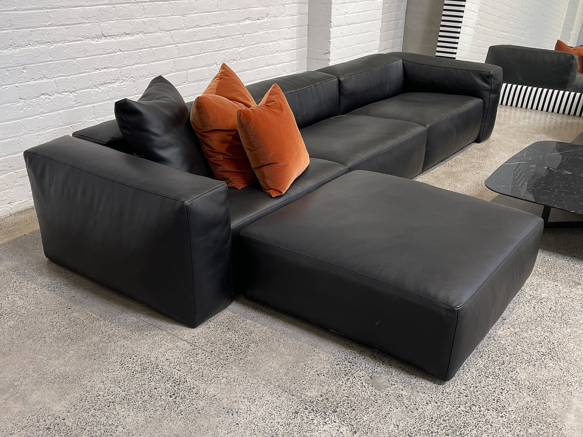 Aspettami leather modular furniture collection in black Kalahari leather in showroom.